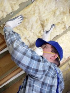 worker insulating a house attic 